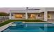 Back of house with a beautiful pool and jacuzzi surrounded by plush green grass, under a covered patio at 6147 E Desert Cove Ave, Scottsdale, AZ 85254