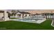 A backyard pool with jacuzzi is surrounded by green turf, creating a tranquil and luxurious outdoor space at 6147 E Desert Cove Ave, Scottsdale, AZ 85254
