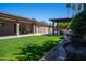 Expansive backyard with lush lawn, covered patio, pergola and inviting pool area at 6529 E Voltaire Ave, Scottsdale, AZ 85254