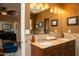Bathroom featuring a dual vanity with granite countertop, warm lighting, and decorative mirror at 6529 E Voltaire Ave, Scottsdale, AZ 85254