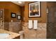 A warm-toned bathroom features tiled walls, granite counters, and decorative wall art at 6529 E Voltaire Ave, Scottsdale, AZ 85254