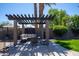 Relaxing outdoor space with a pergola, comfortable seating, and a stone fire pit at 6529 E Voltaire Ave, Scottsdale, AZ 85254