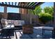 Cozy pergola area featuring comfortable seating and a rustic stone fire pit at 6529 E Voltaire Ave, Scottsdale, AZ 85254