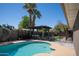 Backyard pool area with a grill, mature trees, and a pergola at 6529 E Voltaire Ave, Scottsdale, AZ 85254