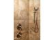 Close-up of a tiled shower featuring a handheld shower head and bronze fixtures at 6529 E Voltaire Ave, Scottsdale, AZ 85254