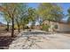 Wide shot of the backyard featuring mature trees, stone firepit and a covered patio at 6659 W Oraibi Dr, Glendale, AZ 85308