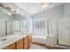 Bathroom boasts a double vanity, soaking tub with glass block window and glass shower stall at 6659 W Oraibi Dr, Glendale, AZ 85308
