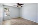 This vacant bedroom includes tile floors, a ceiling fan and bright natural light at 6659 W Oraibi Dr, Glendale, AZ 85308