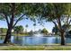 Scenic community lake featuring a fountain, mature trees, and well-maintained landscaping, creating a tranquil and inviting atmosphere at 6659 W Oraibi Dr, Glendale, AZ 85308