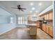 Open kitchen showcases tile flooring, a center island with seating, stainless steel appliances, and a ceiling fan at 6659 W Oraibi Dr, Glendale, AZ 85308