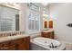 Large soaking tub in primary bath with dual vanities and plantation shutters at 7201 E Sandia Cir, Mesa, AZ 85207