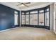 Inviting bedroom features a ceiling fan and plentiful windows with shutters at 7201 E Sandia Cir, Mesa, AZ 85207