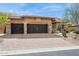 Charming home with a paver driveway and a three-car garage with decorative stone accents at 7201 E Sandia Cir, Mesa, AZ 85207