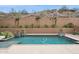 Backyard pool area surrounded by desert landscaping and a retaining wall for privacy at 7201 E Sandia Cir, Mesa, AZ 85207