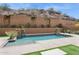 Inviting pool area featuring a private backyard with desert landscaping and a retaining wall for added seclusion at 7201 E Sandia Cir, Mesa, AZ 85207