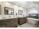 Modern bathroom with dual vanities, soaking tub, arched window, and stylish fixtures at 7245 E Buena Terra Way, Scottsdale, AZ 85250