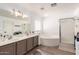 This bathroom features double sinks, large mirror, soaking tub, and a glass shower at 7650 E Williams Dr # 1011, Scottsdale, AZ 85255