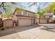 Exterior view of a two story home with a two car garage and desert landscaping at 7650 E Williams Dr # 1011, Scottsdale, AZ 85255