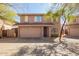 Charming two-story home featuring a two-car garage, arched windows, and mature trees for shade at 7650 E Williams Dr # 1011, Scottsdale, AZ 85255