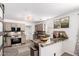 Well-lit kitchen featuring granite counters, stainless steel appliances, and stylish taupe cabinets at 7650 E Williams Dr # 1011, Scottsdale, AZ 85255