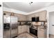 Modern kitchen features stainless steel appliances, tile backsplash, and stylish taupe cabinets at 7650 E Williams Dr # 1011, Scottsdale, AZ 85255