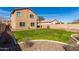 Beautiful backyard featuring a green lawn and a beige two-story home at 811 E Gold Dust Way, San Tan Valley, AZ 85143