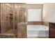 A well designed bathroom includes a separate tub and shower with beautiful brown tile at 811 E Gold Dust Way, San Tan Valley, AZ 85143