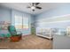 A Bedroom with gray and blue walls featuring a wooden rocking chair and a white crib at 811 E Gold Dust Way, San Tan Valley, AZ 85143