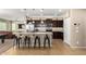 Open-concept kitchen with a central island, dark wood cabinets, and stainless steel appliances, ideal for entertaining at 811 E Gold Dust Way, San Tan Valley, AZ 85143