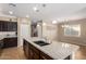 Spacious kitchen featuring granite countertops, stainless steel sink, and dark wood cabinets at 811 E Gold Dust Way, San Tan Valley, AZ 85143