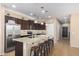 Bright kitchen featuring a central island with bar stools, stainless steel appliances, and dark wood cabinetry at 811 E Gold Dust Way, San Tan Valley, AZ 85143