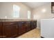 A laundry room with dark cabinets and countertop, two windows, a tile floor, and a white washer at 811 E Gold Dust Way, San Tan Valley, AZ 85143