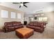 Open living room with plush leather sofas and a view into the kitchen and game room at 811 E Gold Dust Way, San Tan Valley, AZ 85143
