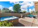 Backyard featuring a hot tub, grill, and an in-ground pool surrounded by attractive hardscaping at 8209 E Heatherbrae Ave, Scottsdale, AZ 85251