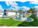 Inviting backyard featuring a pool, lounge chairs, and lush green lawn, perfect for outdoor relaxation at 8213 E Fairmount Ave, Scottsdale, AZ 85251