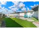 Lush backyard featuring a pool, lounge chairs, and palm trees under a bright blue sky at 8213 E Fairmount Ave, Scottsdale, AZ 85251