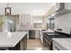 Well-lit kitchen showcasing stainless steel appliances, white cabinets, and a stylish backsplash at 8213 E Fairmount Ave, Scottsdale, AZ 85251