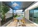 Inviting patio featuring a modern pergola, stylish dining set, and a view of the lush backyard at 8213 E Fairmount Ave, Scottsdale, AZ 85251