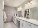 Bright bathroom featuring double sinks, marble countertops, modern tile, and updated fixtures at 8227 N 15Th Pl, Phoenix, AZ 85020