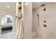 Luxurious walk-in shower with tiled walls, dual shower heads, and a built-in seat; adjacent to the main bedroom at 8227 N 15Th Pl, Phoenix, AZ 85020
