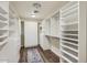 Bright walk-in closet featuring custom shelving, cabinets, and stylish rug for functional storage at 8227 N 15Th Pl, Phoenix, AZ 85020
