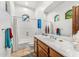 Bright bathroom featuring white tiling, wood vanity, large mirror and bathtub with shower at 9630 E Preserve Way, Scottsdale, AZ 85262