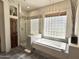 Bright bathroom showcasing a glass-enclosed shower, luxurious soaking tub, and decorative lighting fixtures at 9630 E Preserve Way, Scottsdale, AZ 85262