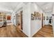 Hallway featuring decorative photos and an arched entryway with hardwood floors at 9630 E Preserve Way, Scottsdale, AZ 85262