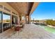 Spacious covered patio with outdoor dining, travertine tile, and lush landscaping, perfect for elegant entertaining at 9630 E Preserve Way, Scottsdale, AZ 85262