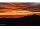 Stunning desert sunset features vibrant orange clouds over the silhouette of the mountains in the distance at 9630 E Preserve Way, Scottsdale, AZ 85262