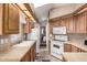 Functional kitchen featuring wood cabinets, and white appliances, offering a practical cooking space at 9736 E Main St # 43, Mesa, AZ 85207