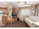 Cozy living room featuring a window, a sofa, wooden kitchen cabinets and an adjacent kitchen area at 9736 E Main St # 43, Mesa, AZ 85207