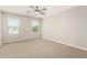 This bedroom is spacious and bright, with neutral carpet and walls and two windows for natural light at 1021 W Vineyard Plains Dr, San Tan Valley, AZ 85143