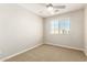 This bedroom has neutral walls, neutral carpet, a ceiling fan, and a window with blinds at 1021 W Vineyard Plains Dr, San Tan Valley, AZ 85143